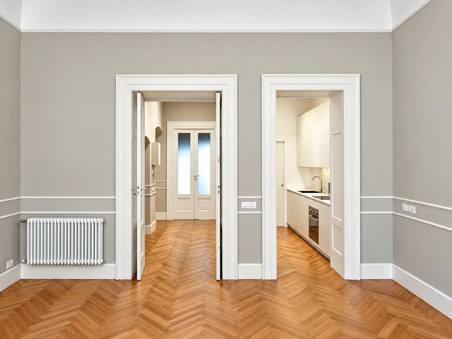 Casa LaL: la sala da pranzo con il parquet a spina di pesce e le porte con cornici bianche