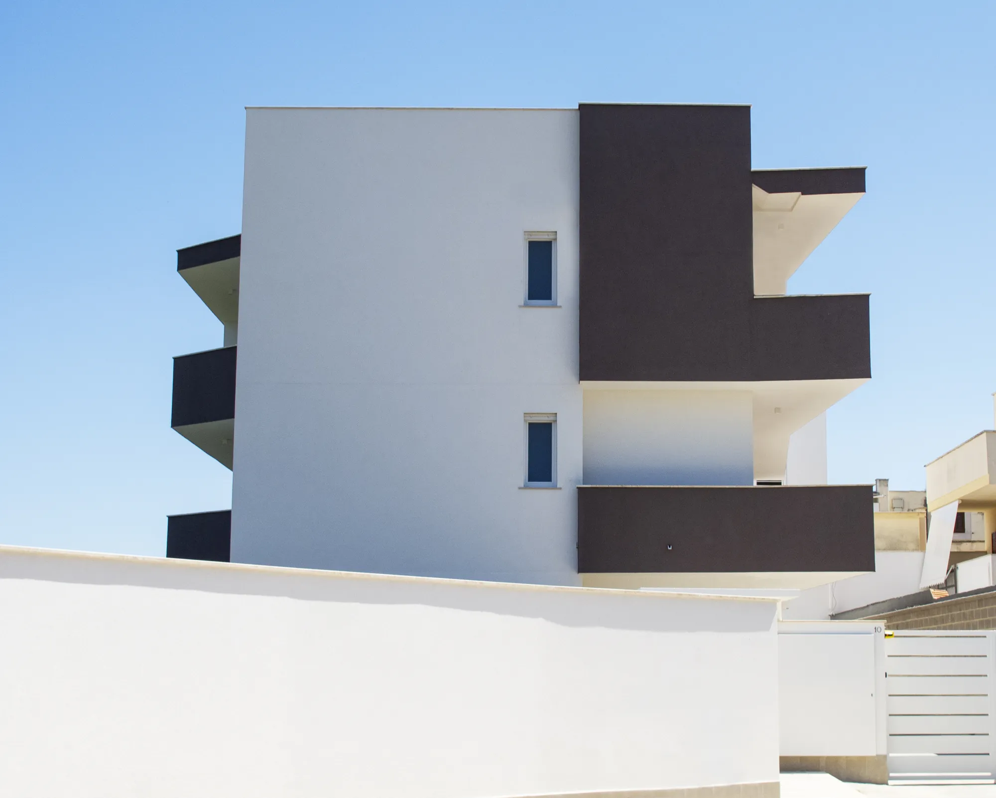 Via Pasolini: Il prospetto ovest, pareti bianche e volumi scuri